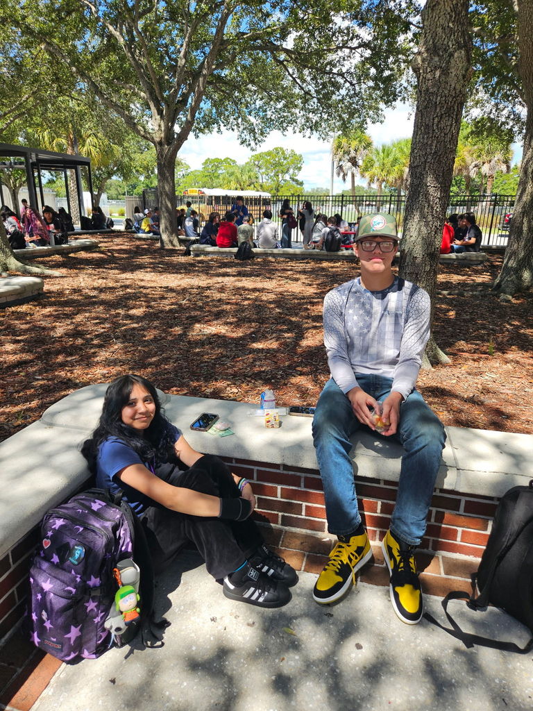 boy and girl sitting in courtyard during lunch