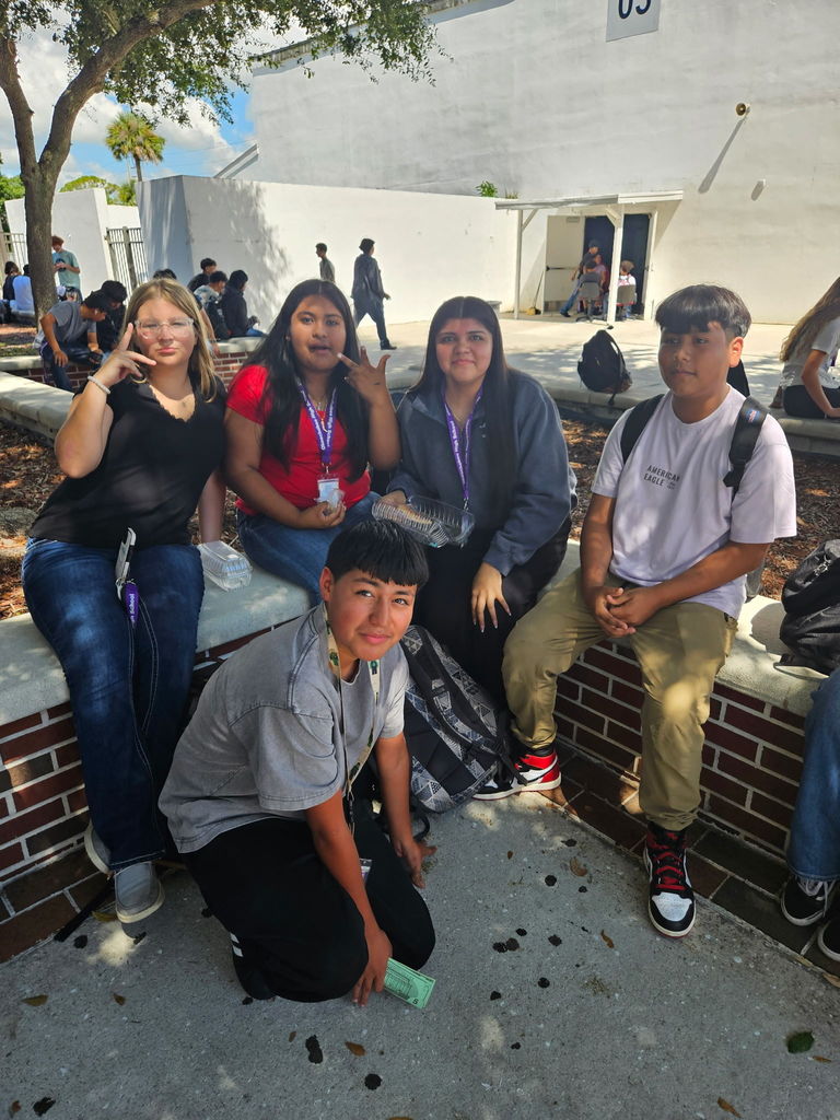 five students sitting in courtyard during lunch