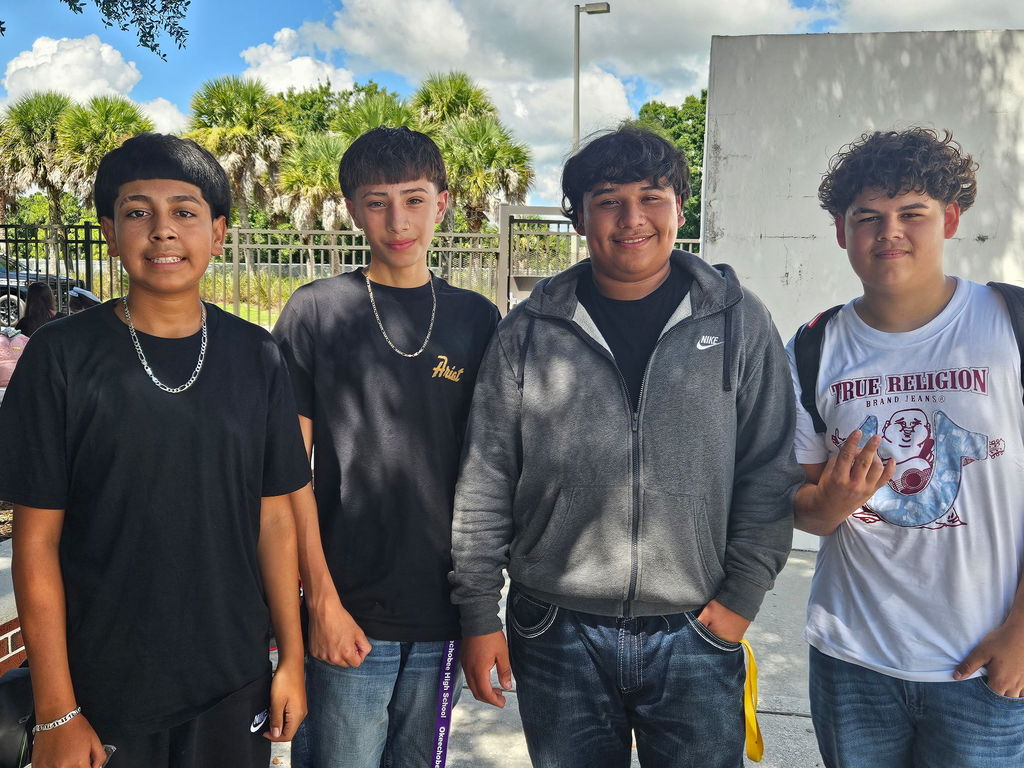 four boys standing in courtyard during lunch