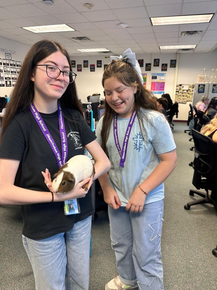 two girls holding guinea pig