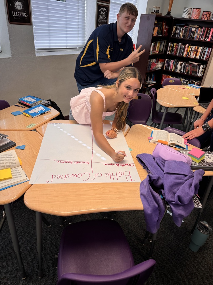 two students working on a poster in English class
