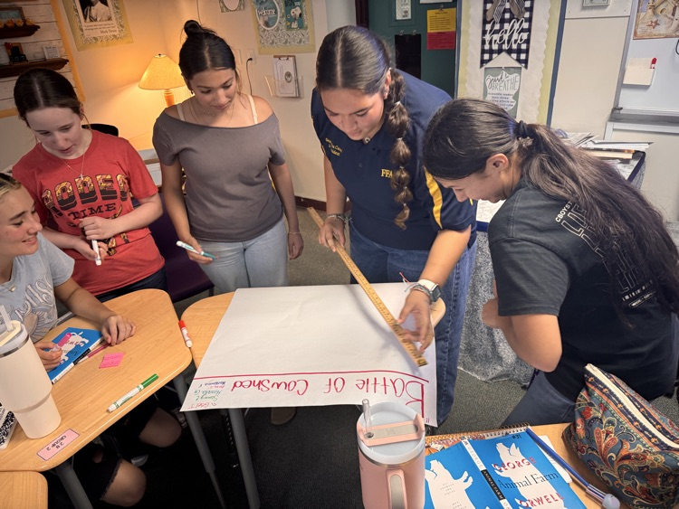 five students working on poster in English class