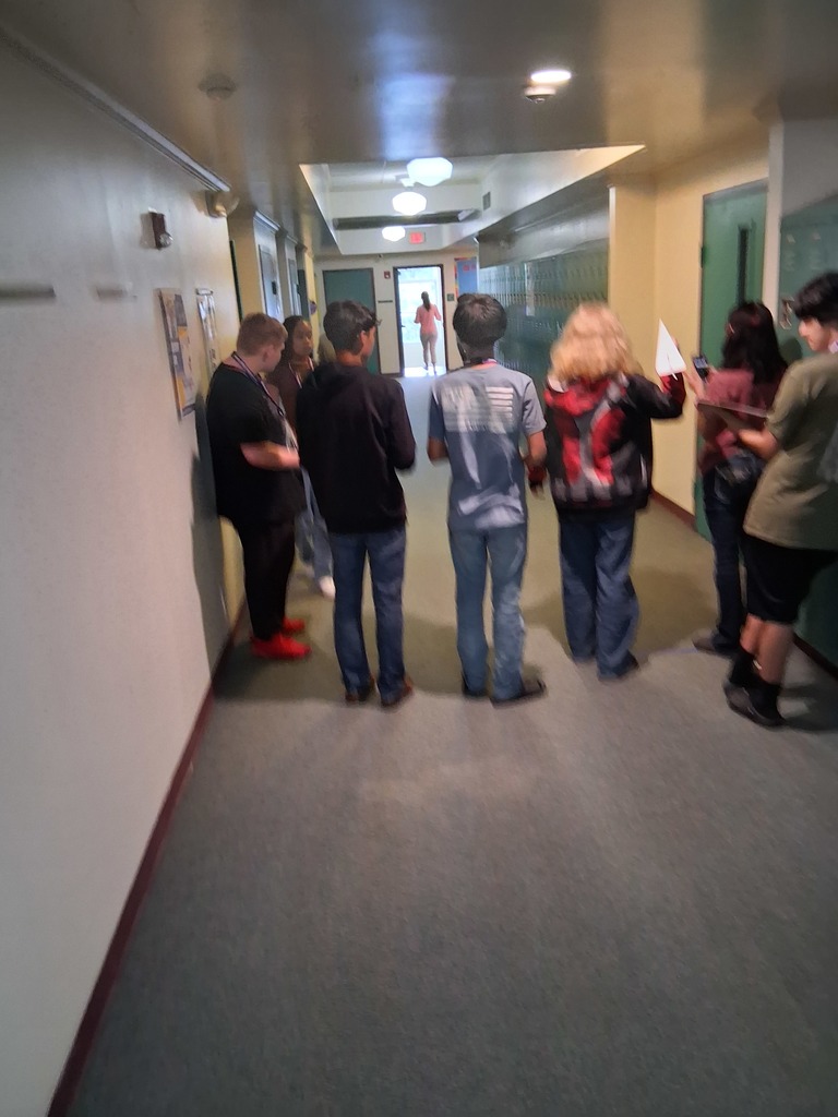 students in hallway doing airplane challenge 
