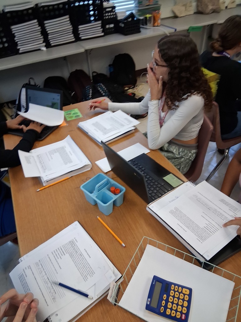 student on computer with other students working on experiment in her table
