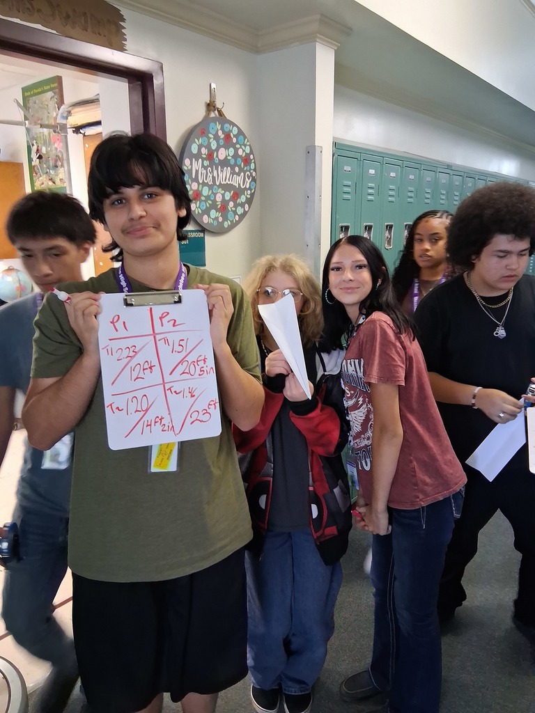six students in hallway doing airplane science project