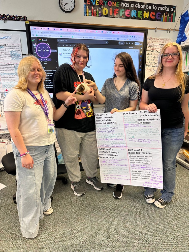 four students holding up dok poster