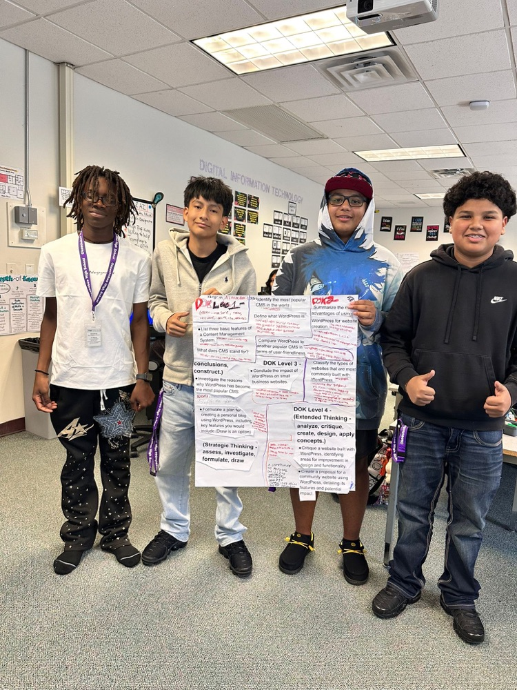 four students holding up dok poster