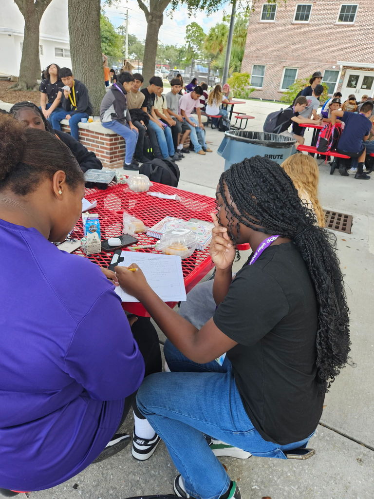 students working on homework during lunch in the courtyard