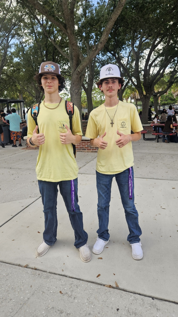 two students wearing yellow outside the courtyard