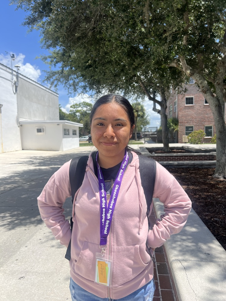female student standing outside school courtyard