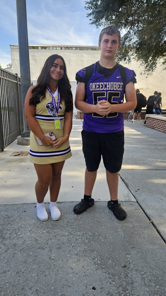 cheerleader and football player in courtyard