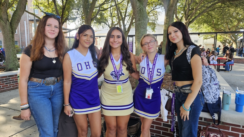 five girls in the courtyard and three in cheer uniforms