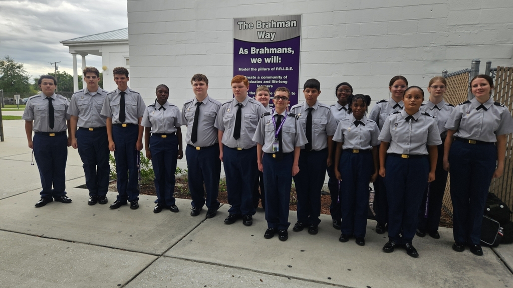 fifteen JROTC students in uniform standing in school courtyard