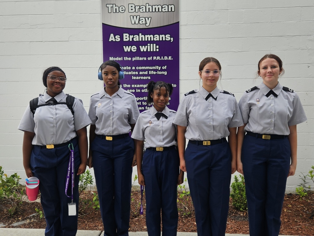 five JROTC students with uniform standing in school courtyard