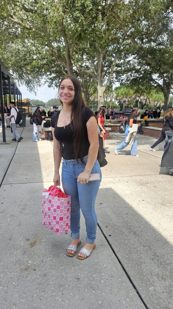 student holding gift in courtyard