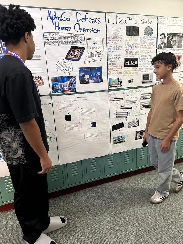 two students presenting AI poster in hallway