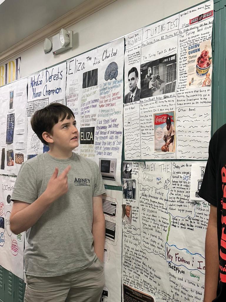 student presenting his AI poster in hallway