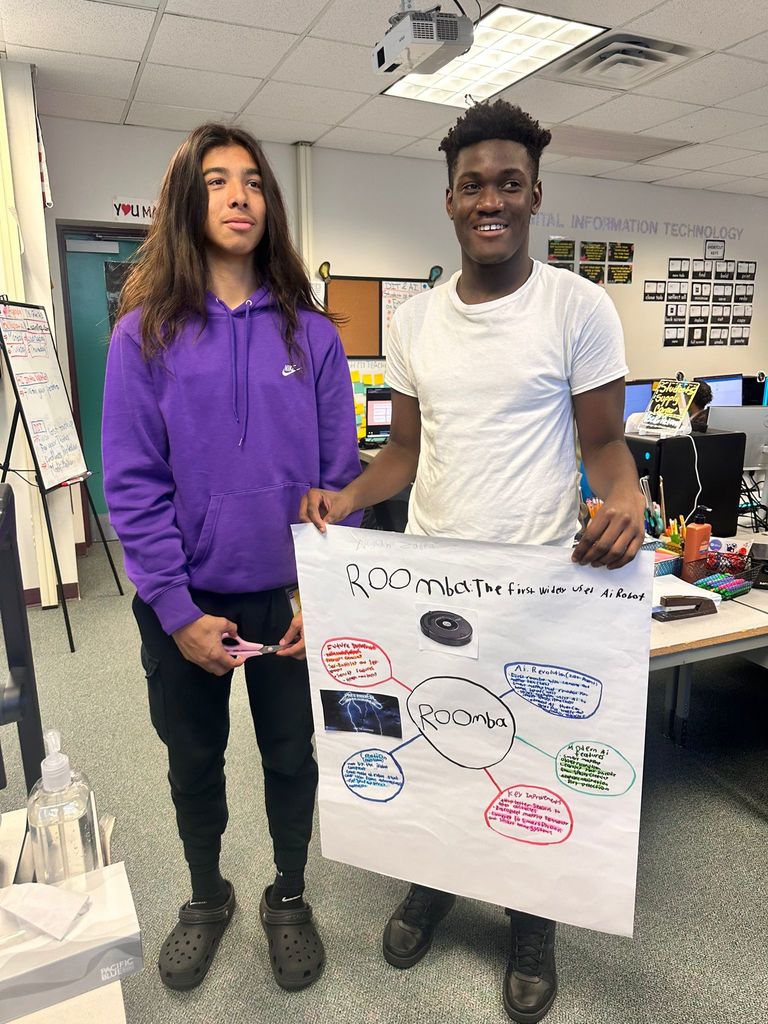 two students showing off their AI poster in class