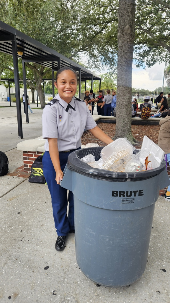 cadet helping with trash during lunch in courtyard