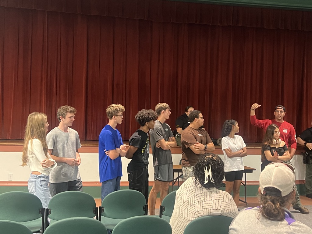 students standing Infront of auditorium stage
