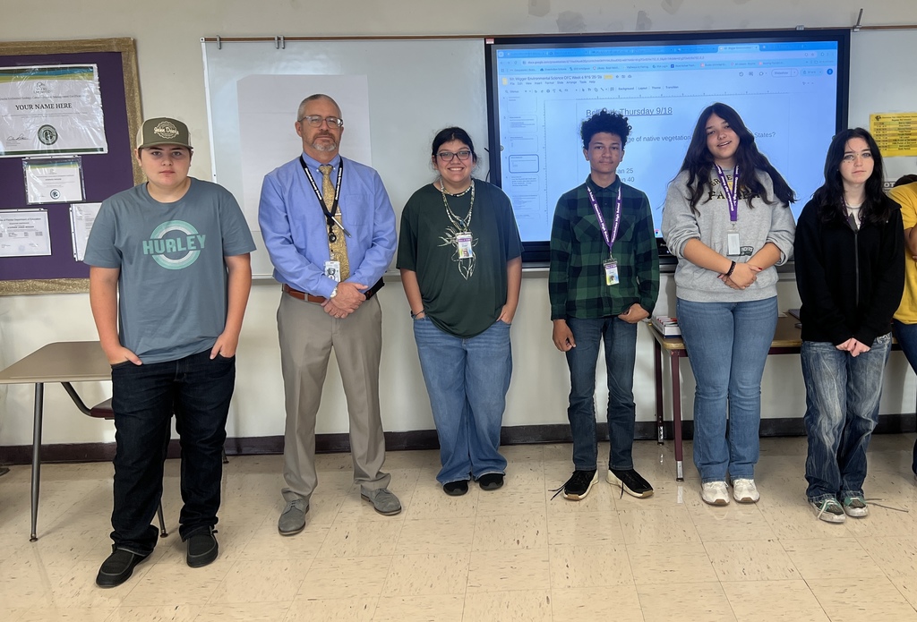 superintendent standing with five science students