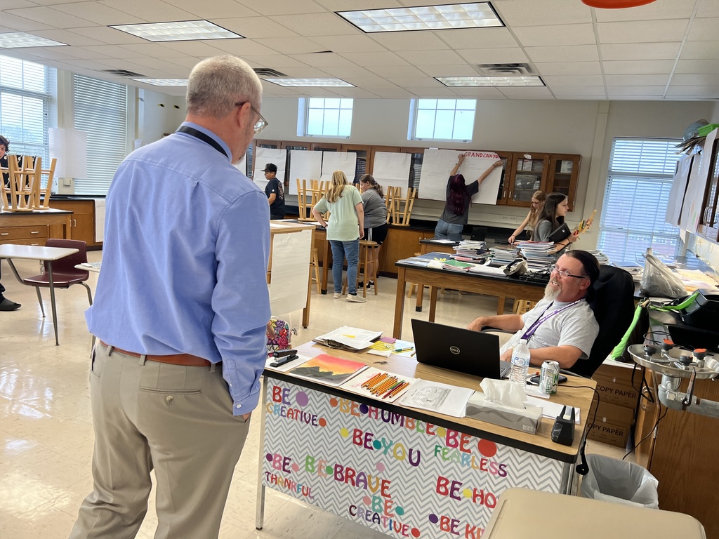 superintendent talking to science teacher