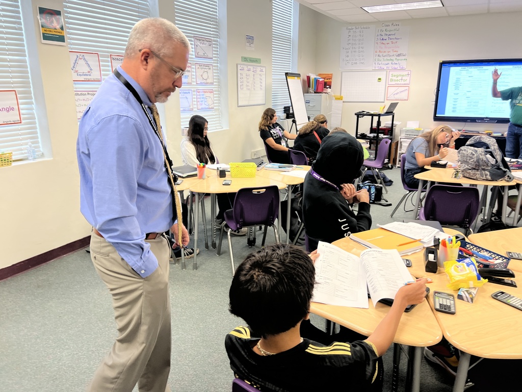 superintendent talking to student in classroom