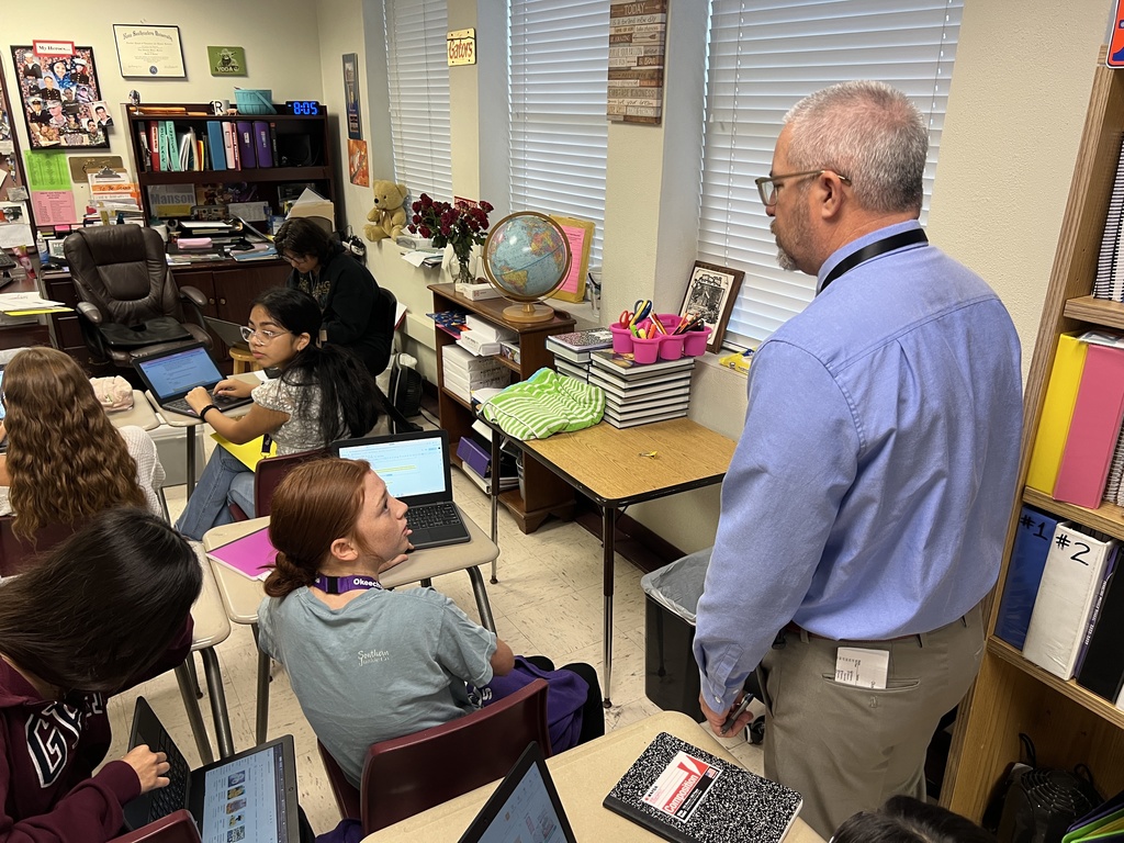 superintendent talking to student in classroom