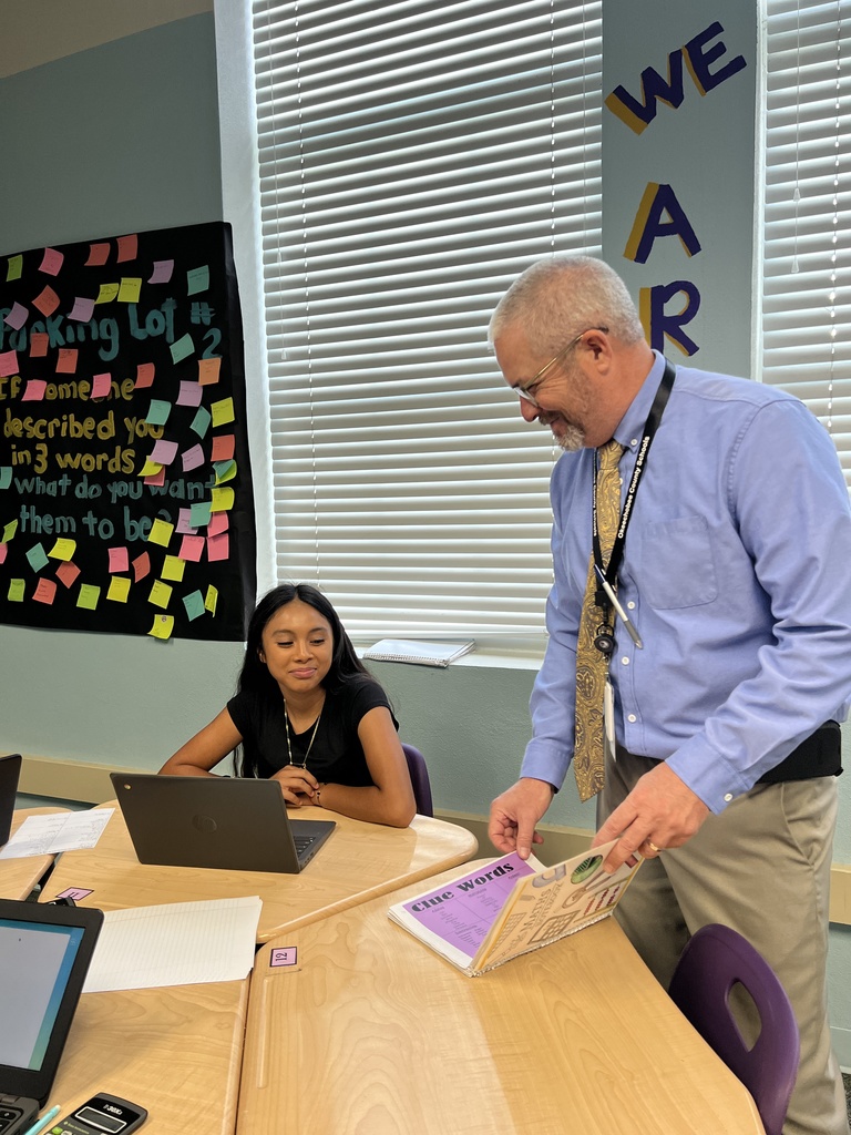 superintendent talking to student in classroom