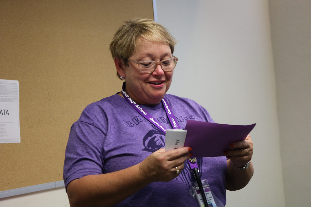 principal smiling looking at student of the month certificate