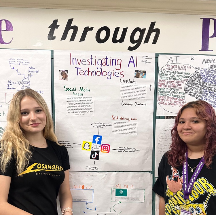 two female students infront of school posters they made