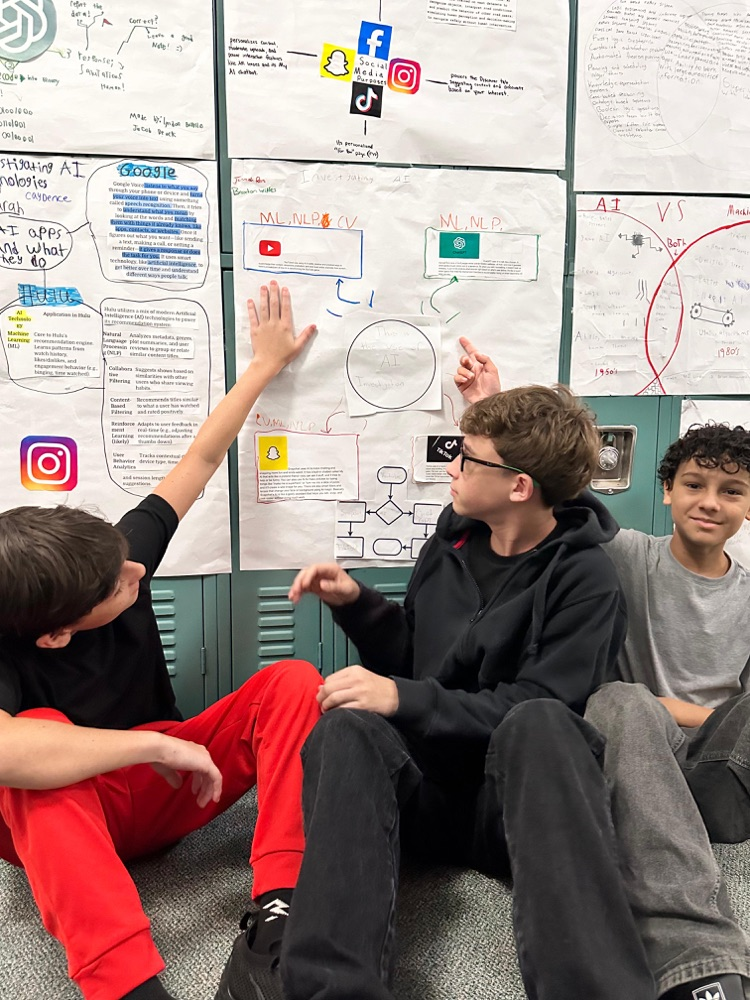 students showing their poster hung on lockers