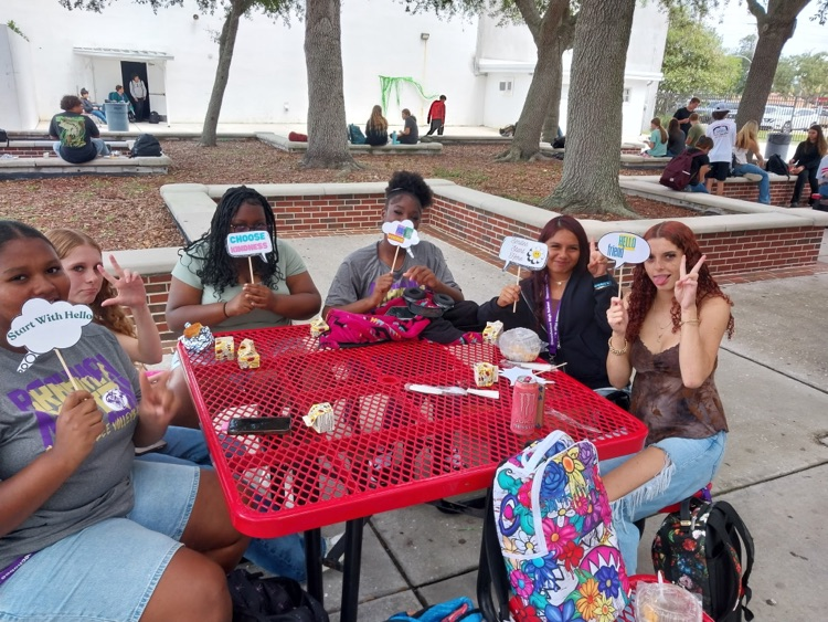six students in school courtyard sitting in table during lunch