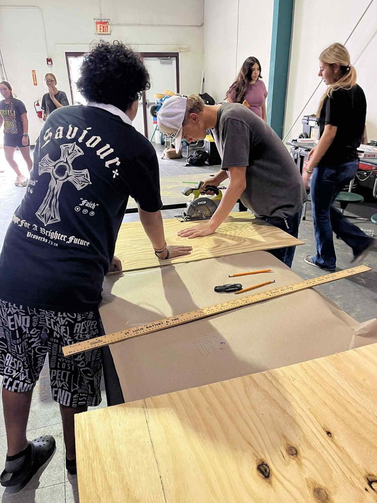 students working in gym on float building