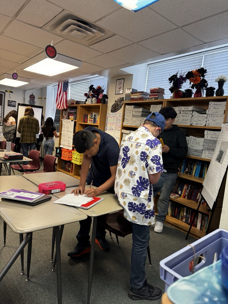 students writing down standing up around the English room 