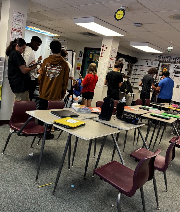 students writing down standing up around the English room 