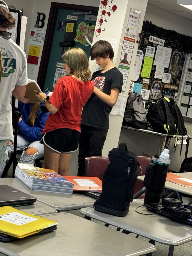 students writing down standing up around the English room 