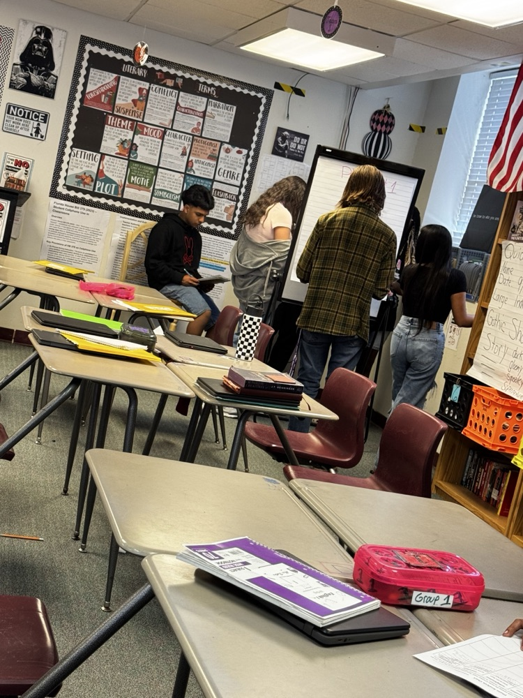 students writing down standing up around the English room 