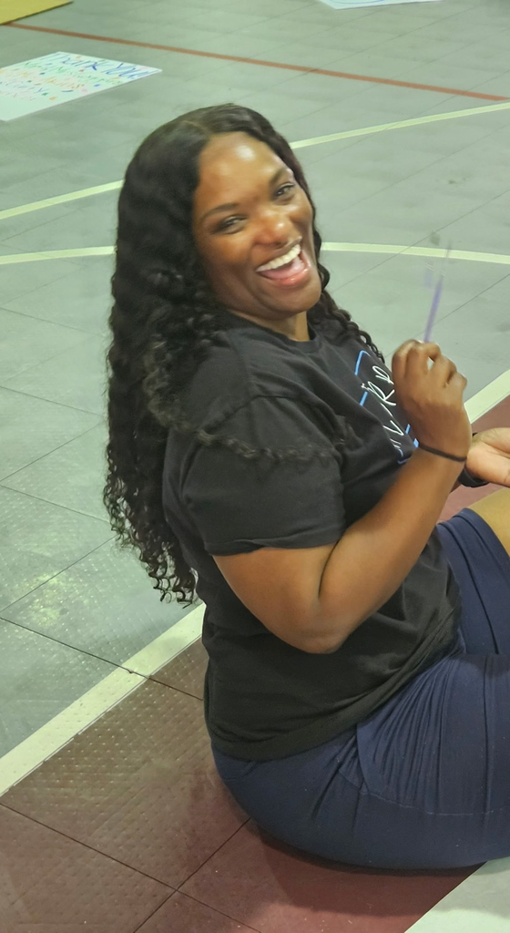 guidance counselor laughing sitting on gym floor