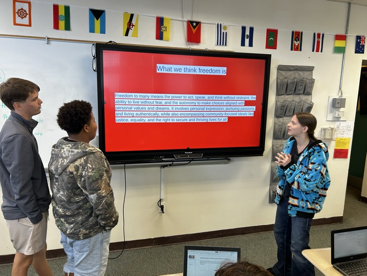 three students presenting slideshow for celebrate freedom week