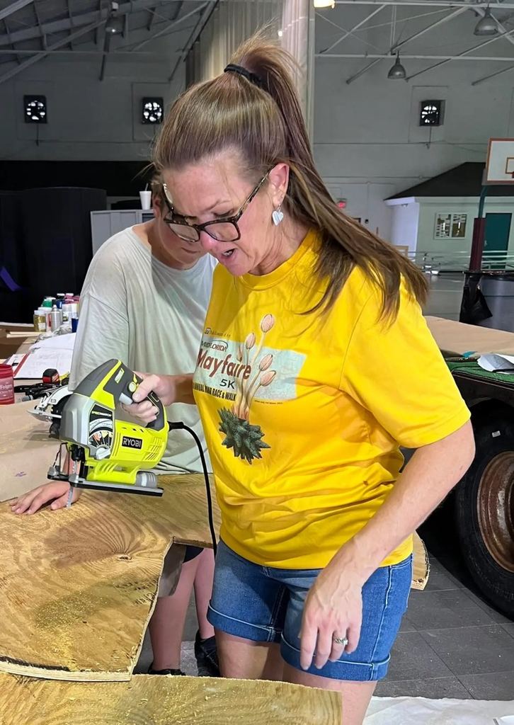 teacher using saw for float building