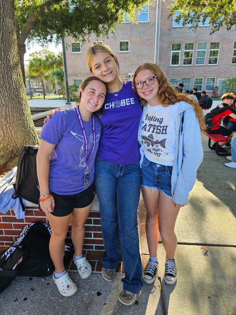 three girls wearing mascot shirts Brahman and catfish in school courtyard