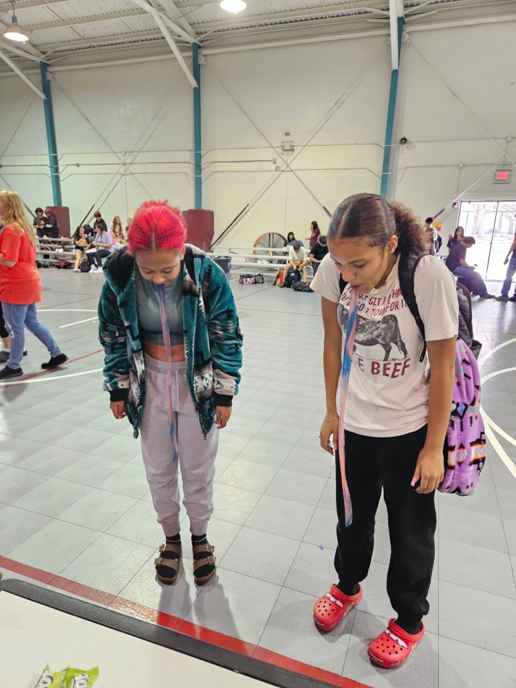 two girls playing fruit roll up game in gym 