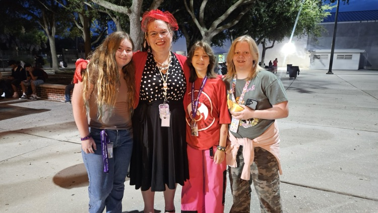teacher hugging three girls dressed for homecoming week