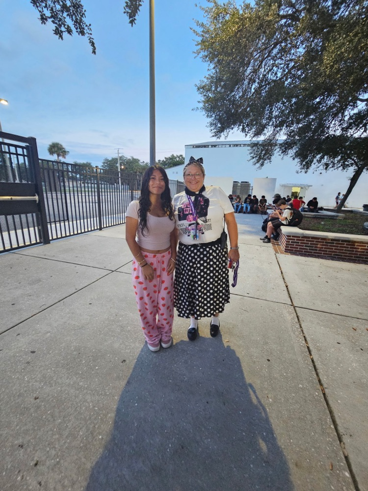 principal and student dressed for spirit week in courtyard of school