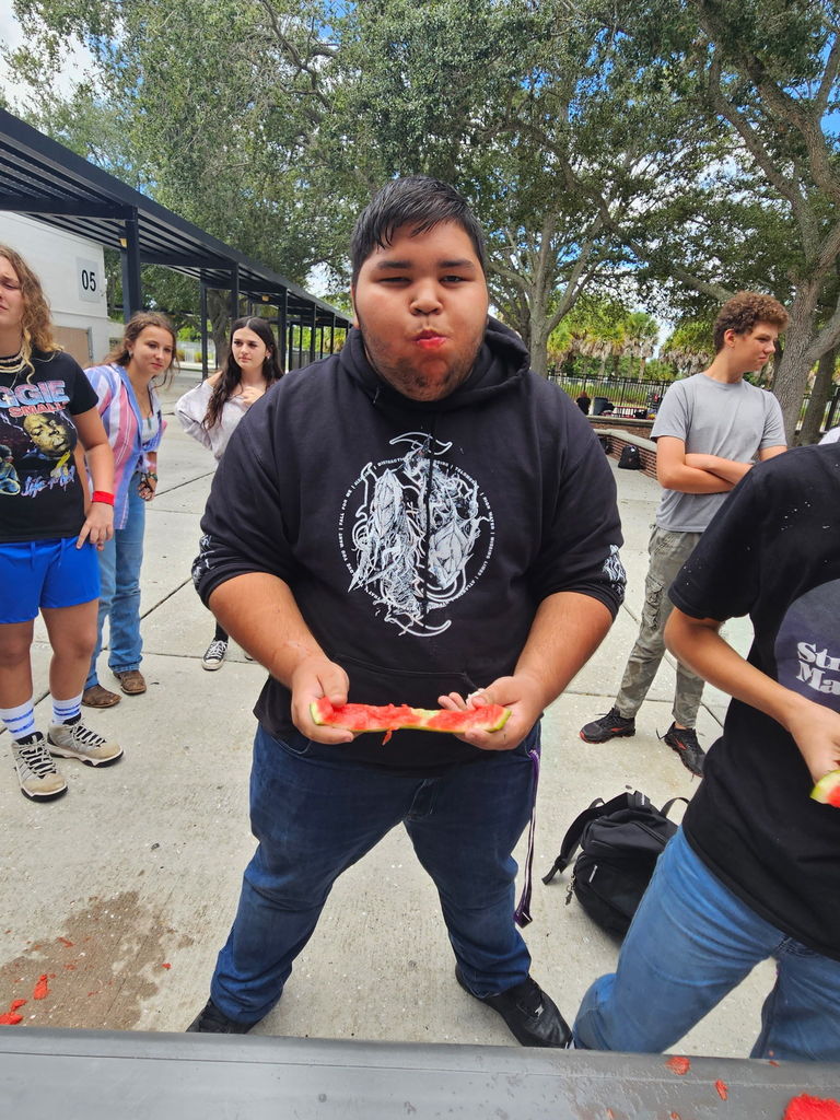 student with mouth stuffed with watermelon during homecoming games