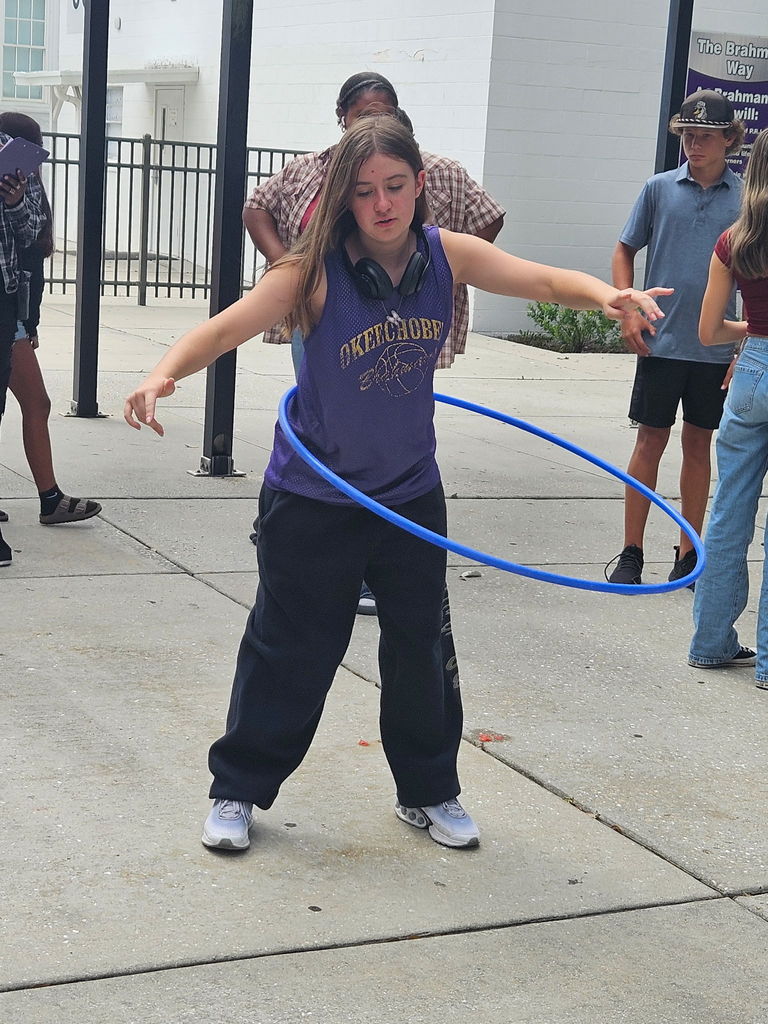 student doing hula hoop outside school courtyard
