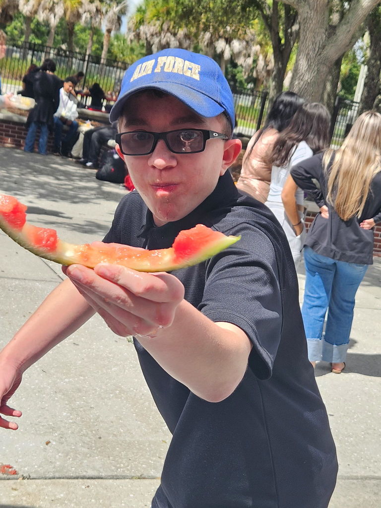 student showing he finished eating all the watermelon slice