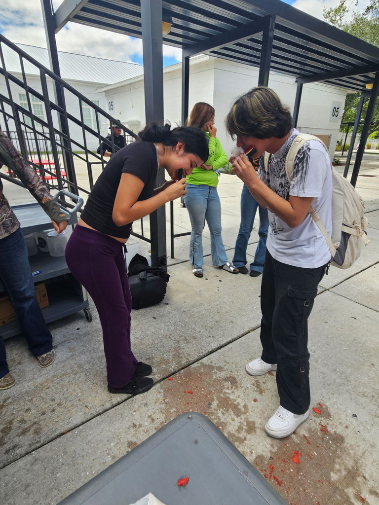 two students eating watermelons for homecoming competition