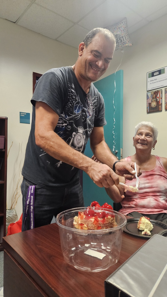 school custodian in office cutting birthday cake